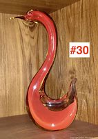 Full side view of Murano glass bird/duck figurine with orange interior and clear outer glass, displaying fluid curved neck and body.