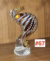 Front view of amber and white swirled seahorse on textured clear glass base.