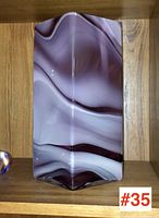 Photo of the front side showing swirling soft purple and white layered patterns in the glass vase with a hexagonal shape.