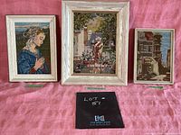Three framed embroidery artworks displayed on a pink surface, showing the full lot.