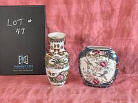 Pair of Oriental vases set against a pink background, one tall Chinese vase with painted figures and ornate details, and one shorter Japanese vase with floral decoration.