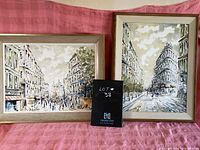 Two framed city street scene prints depicting Parisian architecture and pedestrians, with one closer look at one print displaying trees, buildings, and people on street.