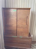 Full view of the teak bureau showing two sliding doors on the upper cabinet and two drawers beneath.