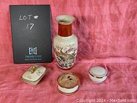 Photo of vase with peacock motif along with three covered trinket boxes on pink cloth backdrop, showing all items.