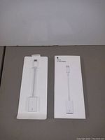 Front and back view of Apple USB-C to USB Adapter in retail packaging showing USB-C male to USB female port adapter