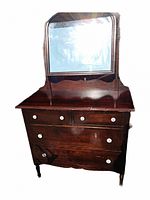 Full view of antique wooden armoire with large mirror, multiple drawers and white round knobs.
