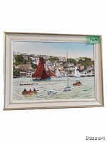 Front view of the watercolor painting showing boats on water and a coastal village scene with red sailboat as focal point, framed in silver frame.