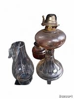 Three vintage hurricane oil lamps shown on a flat surface with one glass chimney placed beside the lamps.