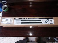 Photo of full boxed lot containing two Ideal garage door springs, showing box on wooden surface.