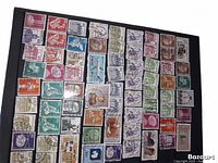 Page from blue stamp album showing a variety of used Canadian stamps mounted on black pages.