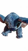 Front close-up of blue Stitch plush showing detailed facial features including eyes, nose, and ears, with original Disney tag visible on ear.