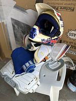 Photo showing HJC helmet with visor resting on a white and blue protective vest.