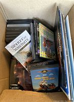 DVDs and vinyl records arranged in a box, visible DVD titles include 'Spirit of Yosemite' and 'Chitty Chitty Bang Bang'.