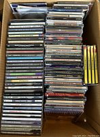 Photo showing rows of vintage CDs with visible titles and artists covering different music genres.