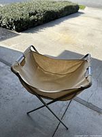 Photo showing the vintage folding canvas basket from a front angle highlighting the canvas body and metal frame.