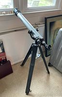 Silver Bushnell Model 78-9512 telescope mounted on black tripod, angled diagonally.