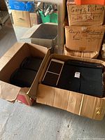 Box of brown and white Aiwa speakers and black Mitsubishi speakers along with a Magnavox stereo CD player packed together.