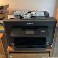 Front view of the Epson Workforce Pro WF-3820 printer with extra ink cartridge boxes on top.