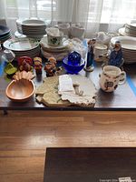 Full lot view showing Goebel figurines, dishes, textured wall art, wood bowl, and Royal Tara tea set