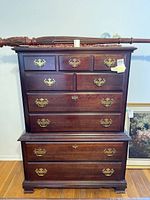 Front view of the tall boy dresser showing the brass handles and cherry wood finish.