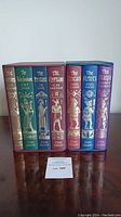 Seven volumes from both box sets upright without slipcases showing spines: The Sumerians, The Babylonians, The Persians, The Egyptians, The Incas, The Aztecs, The Maya.