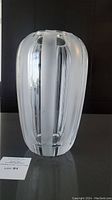 Front view of vase showing alternating frosted and clear vertical glass stripes and rounded scalloped top edge.