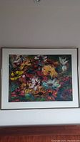 Frontal image of the framed oil painting showing the colorful floral artwork and the white matting with gold frame.