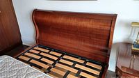 Front view of sleigh style headboard showing wood grain and finish