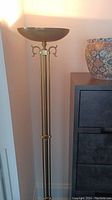 Full view of standing uplight floor lamp showing overall appearance and brushed gold finish