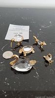 Set of 5 Swarovski crystal animal figurines on black surface with a coin for scale, including a swan, bird, fox, turtle, and duck. Swan is in two pieces.