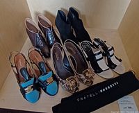 Photo showing multiple women's shoes including boots, pumps, and open-toes on shelf with Fratelli Rossetti dust bag visible