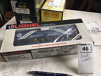 Photo of the Lionel branded boxed Wabash Railroad rolling stock set on a table next to a pen for scale.