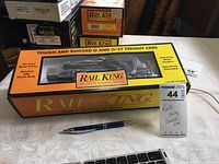 Rail King oil tanker train car in original yellow box with clear window on table including pen for scale.