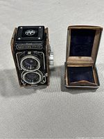 Front and side angled view of Sawyer's Mark IV camera and its open leather case showing interior lining