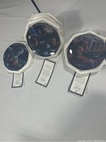 Three octagonal Star Trek The Next Generation plates displayed upright showing their artwork and attached certificate tags.