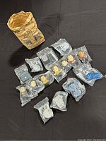 All 15 Star Trek toys from Burger King 2009 promotion displayed together with original paper bag. Toys are sealed in original plastic bags showing character busts and starship models.