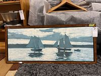 Full view of the framed print showing two sailing ships on calm water with reflections, mounted in a dark wooden frame.