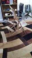 Side view of one retro wooden beach lounger showing frame and striped fabric seat