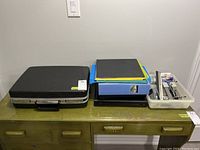 Overview of briefcase, binders, folders, document stand, and office accessories on wooden desk