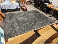 Full view of gray shag area rug placed on light-colored flooring, showing approximate scale and surrounding furniture.
