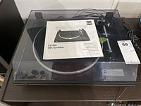 Full view of the Dual CS450 turntable with clear dust cover and manual document on top of the platter.