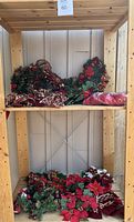 Wide view of shelf containing assorted Christmas wreaths and decor items packed for sale
