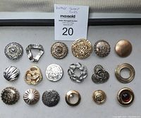 Front view of 18 vintage scarf clips in assorted metal finishes and designs arranged in rows