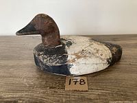 Side view of the wooden duck decoy showing the weathered paint and shape