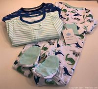 Three Cloud Island baby sleepers laid out, showing the patterns and colors.