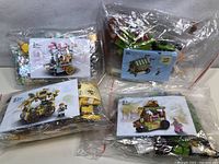 Four sealed bags of building block kits displayed together with instruction manuals showing completed carts and mini-figures.