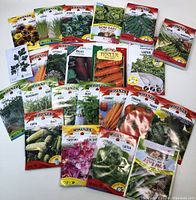 Photo of all various seed packets laid out, showing the variety of vegetable, herb, and flower seeds all sealed.
