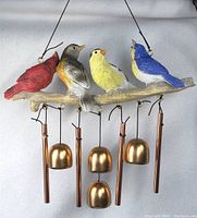 Front view of the birds on a branch wind chime showing the colorful birds and copper-colored chimes and bells.
