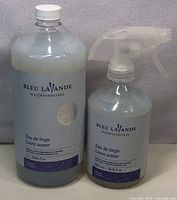 Photo of two linen water bottles from Bleu Lavande Wellessentials, one spray bottle and one refill bottle.