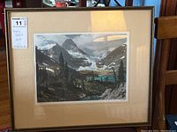 Framed and matted photo showing a mountain scene with lake and trees under cloudy sky in a 17x19.5 inch frame.